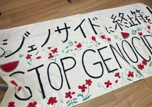 「ジェノサイドに終止符を!STOP GENOCIDE」というメッセージを込めた横断幕